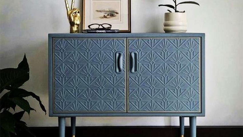 A blue chest with Anaglypta on the doors and tall legs with gold ferrules