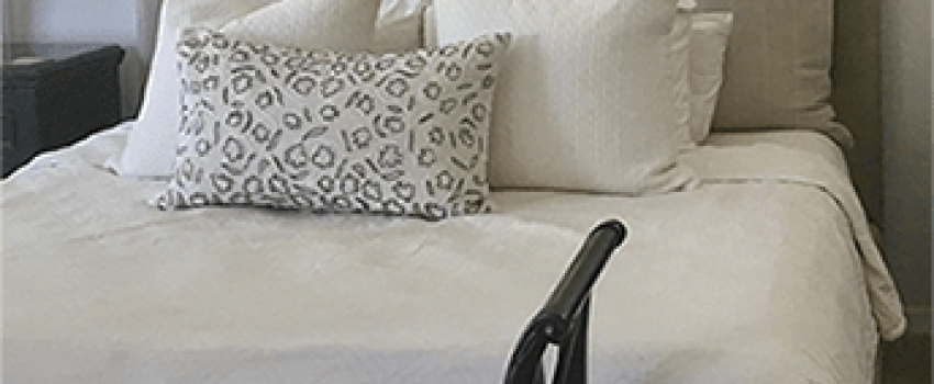 Bed with 6 decorative pillows and a bench at the bottom