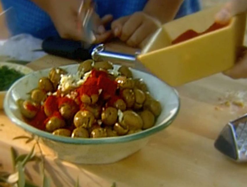 a bowl of cracked olives with evoo and spices