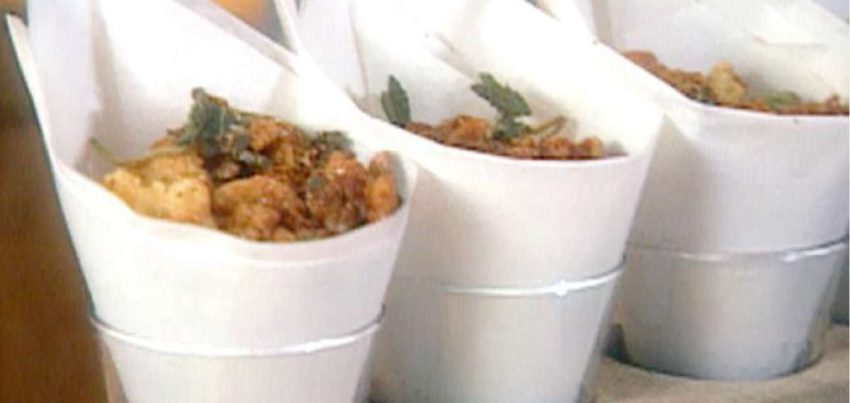 3 clear glasses with paper cones filled with fried beans