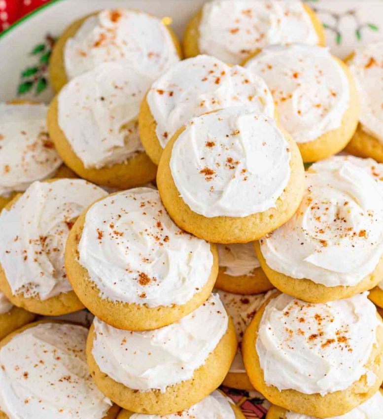 a plate of eggnog cookies with white frosting and a sprinkle of cinnamon