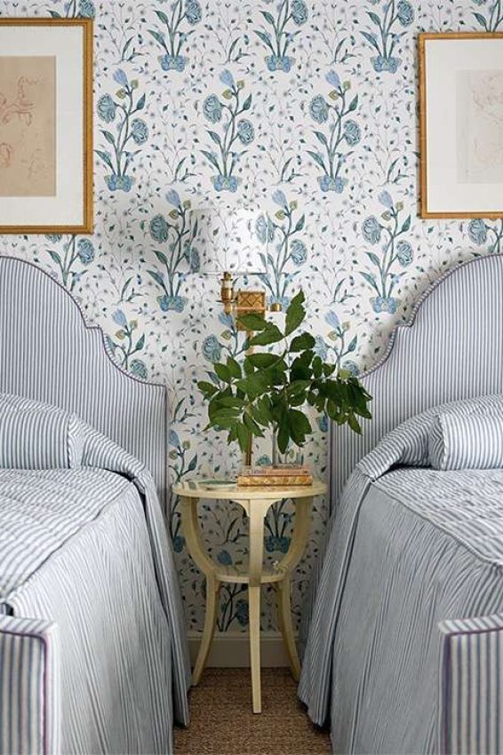 Bedroom with matching upholstery twin beds and blue and white floral wallpaper