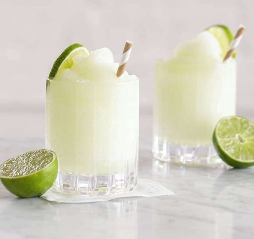 2 glasses of frozen gin & tonics with a lime cut in half