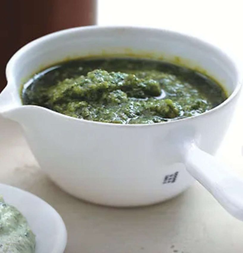 a white crock filled with bright green salsa verde