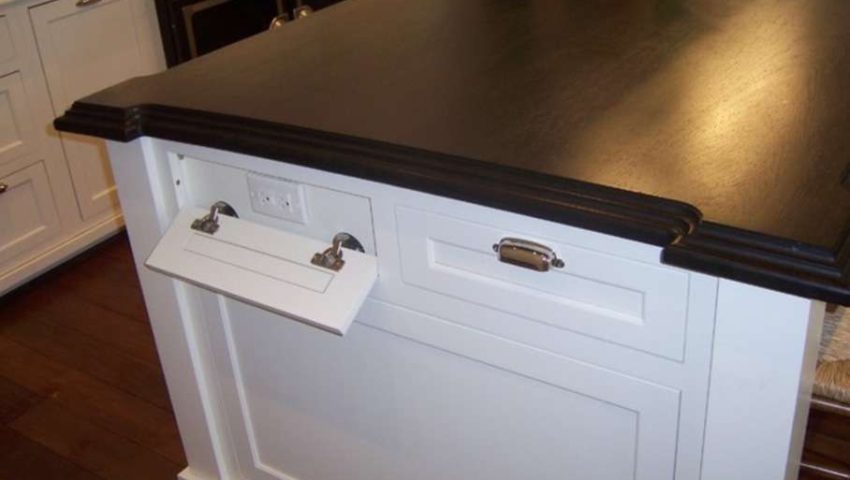 kitchen island with a drawer front that flips down to reveal electrical outlet
