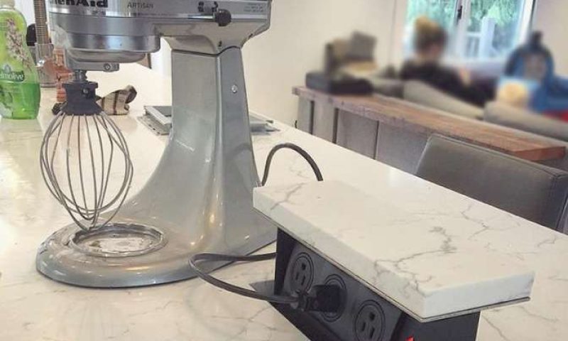 kitchenaid mixer atop kitchen island plugged into pop-up electrical outlet