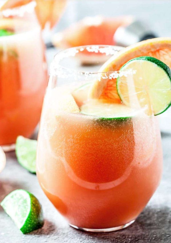 glass filled with paloma cocktail and lime slices