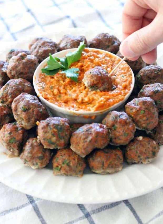 A plate of greek meatballs with romesco sauce for dipping