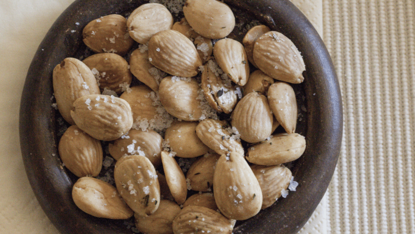 a small wooden bowl filled with spiced marcona almonds