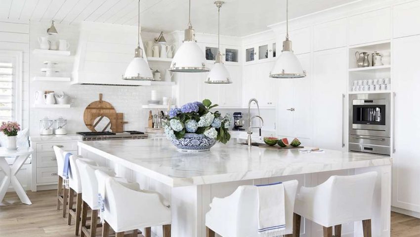 White coastal kitchen with an XL island and glossy white subway tile backsplash