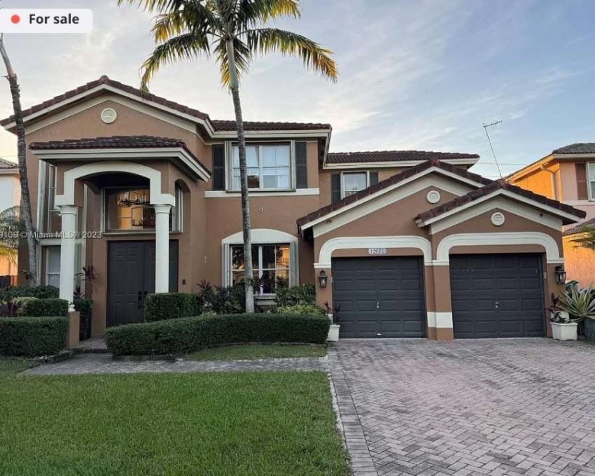 a home exterior painted terracotta-brown with charcoal shutters, garage doors, and front door. It desperately needs a color transformation.