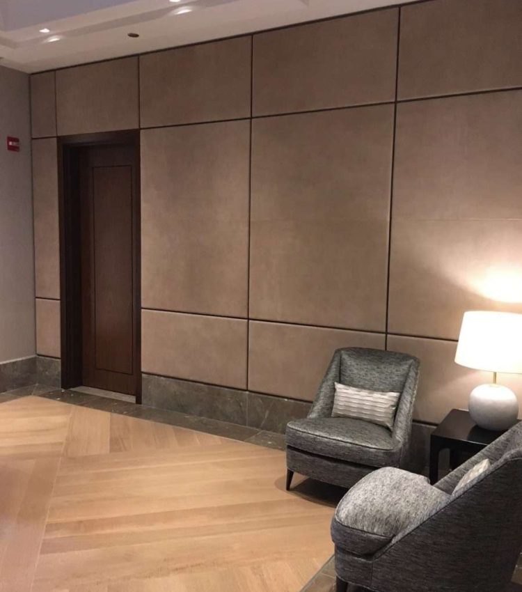 Living room with mocha leather panels on walls and gray chairs