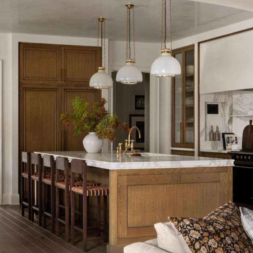a kitchen island with warm wood base and thick marble countertop