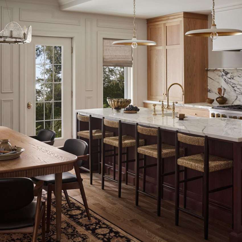 a white kitchen with wood island and marble countertop with sink