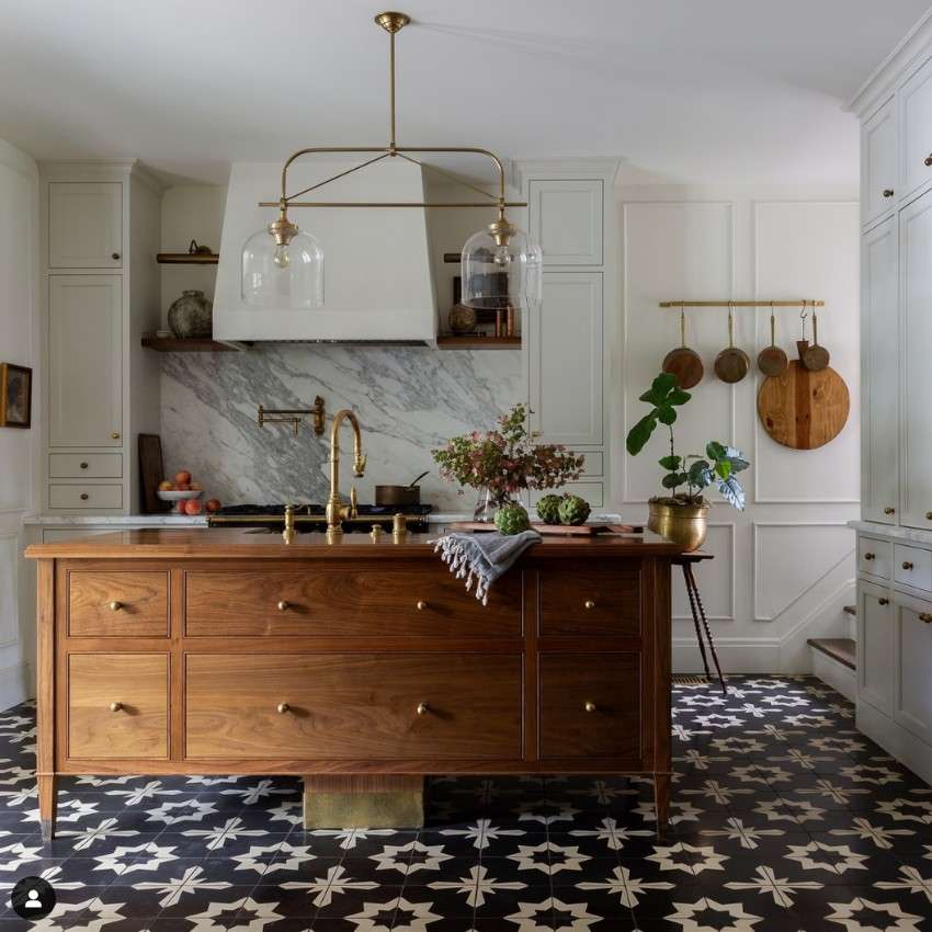 a beautiful custom walnut island with a sink and unlacquered brass fixtures